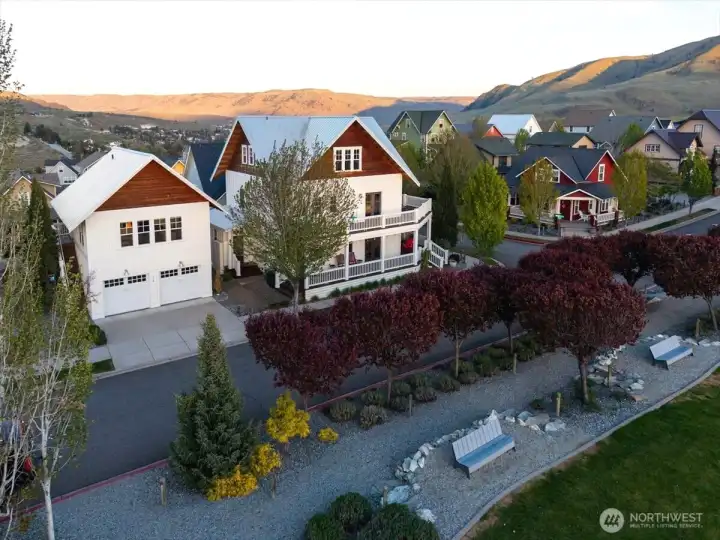 Aerial view of home overlooking the Lookout's Hilltop Park with grassy lawn, playground, outdoor fireplace and BBQ area, pickleball court, clubhouse, pool and hot tub.