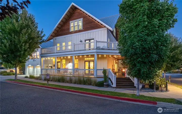 Twilight view 2 of home with classic covered wraparound porch and upper level lake view decks.