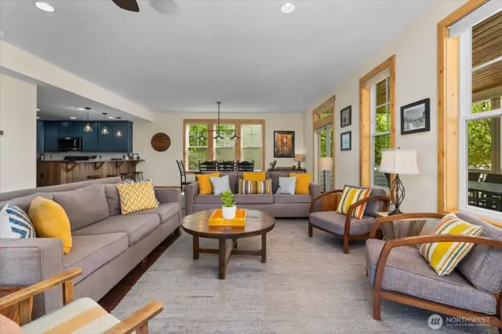 Main level living room with two sets of French doors leading to the covered wraparound porch and outdoor living space.