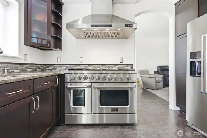 The kitchen features professional-grade appliances and a statement range hood that anchor the space with both style and function. The kitchen features professional-grade appliances and a statement range hood that anchor the space with both style and function.