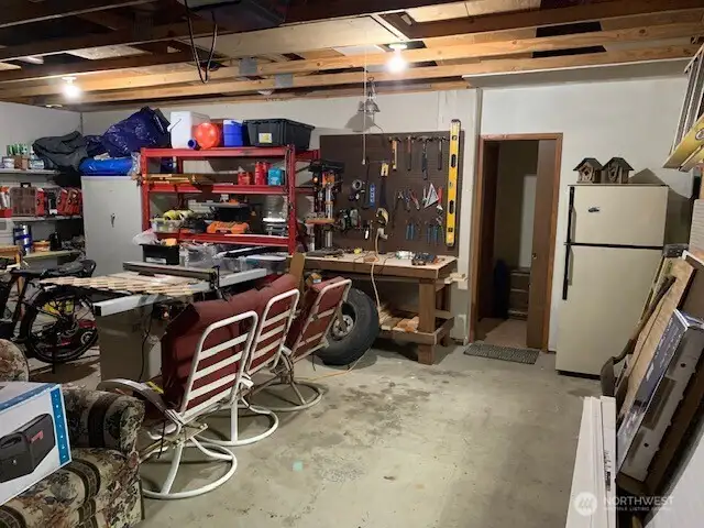 2 car garage with workbench and refrigerator.