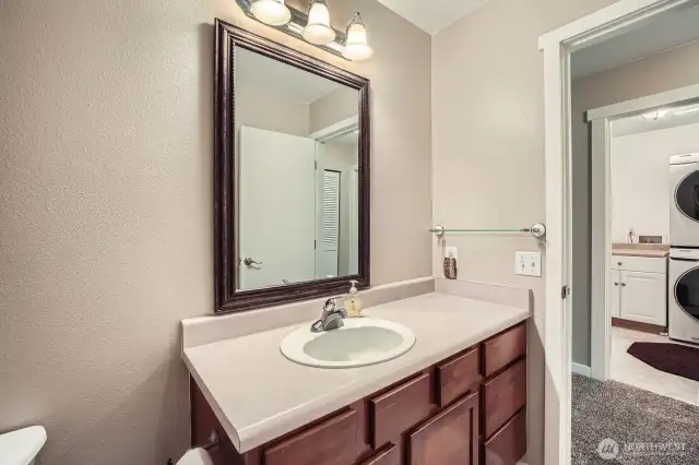 Second floor bathroom opens out into hall across from laundry room