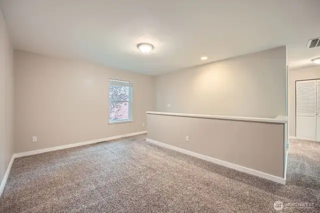 Large loft area at the top of stairs on right the hall leading to the laundry room, bathroom and additional bedrooms