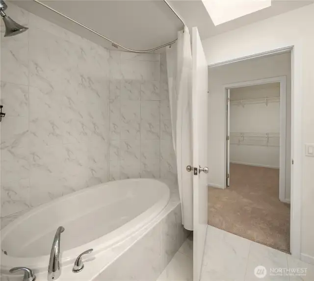 Primary bath with soaking tub across from walk-in closet.