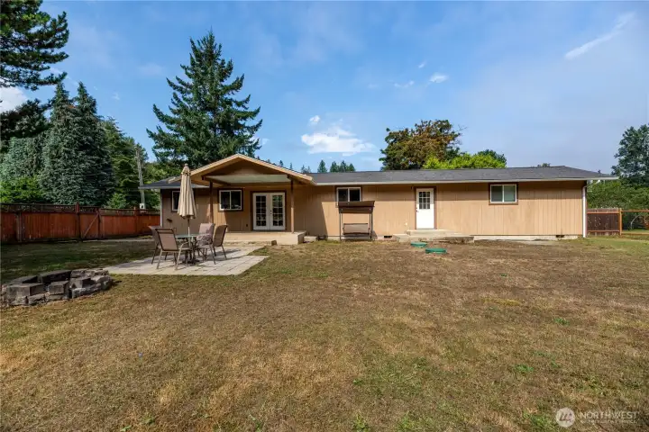 he level yard offers plenty of room for gardening, play, or pets, with mature evergreens adding privacy and a natural backdrop.