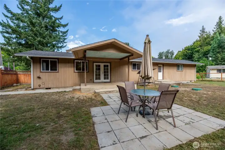 A separate paver patio with seating and umbrella provides an additional gathering space.