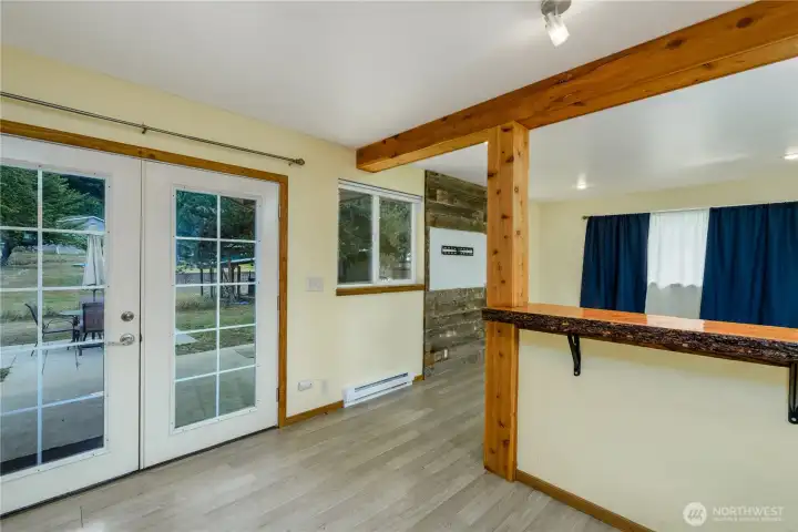 Light-toned flooring enhances the spacious feel, and a French door leads directly outside, extending the living space to the backyard.