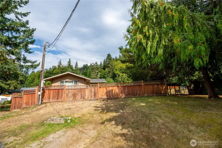 The large lot provides ample outdoor space with mature trees framing the property, creating a serene natural setting.