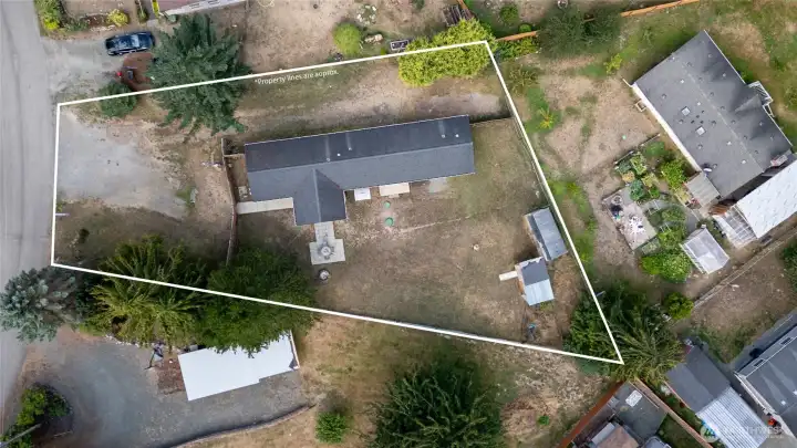 Clear top-down view outlining the property boundaries. The large, fenced lot offers ample outdoor space for gardening, recreation, or future expansion, with easy access to the home and driveway.