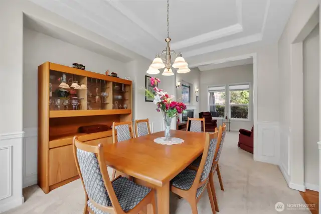 Elegant dining room with conferred ceilings and wainscoting flows from the living room. Space for a large buffett and room for all your gatherings. To the right is the kitchen which makes entertaining a snap!