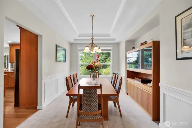 Dining room gets tons of natural light.  High conferred ceilings an wainscoting add a touch of elegance.