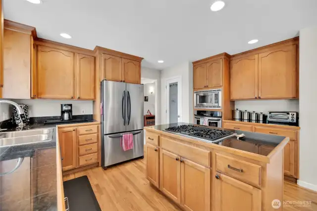 You'll love this kitchen space. Granitce counters, recessed lighting, gas island cooktop with breakfast bar, tons of cabinets, oak hardwoods and step in pantry for all your goodies and extra appliances.