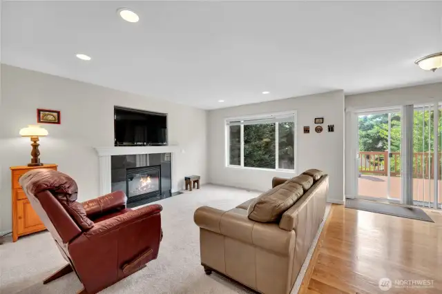 Family room adjacent to the kitchen. Gas fireplace makes a great focal point and the TV fits so perfectly that it will stay with the home. Step out to the spacious deck and enjoy the privacy of the fenced back yard.