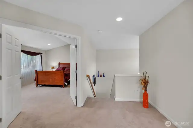Landing area at the top of the stairs looking at the primary bedroom.