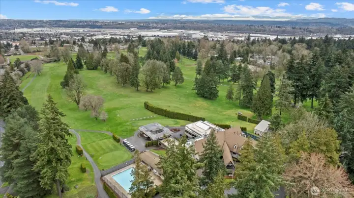 Aerial view of the Clubhouse, pool, golf course and driving range.