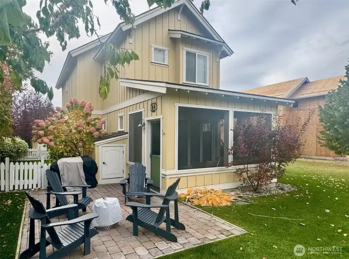 Shaded paver patio in back, bordered by apricot tree