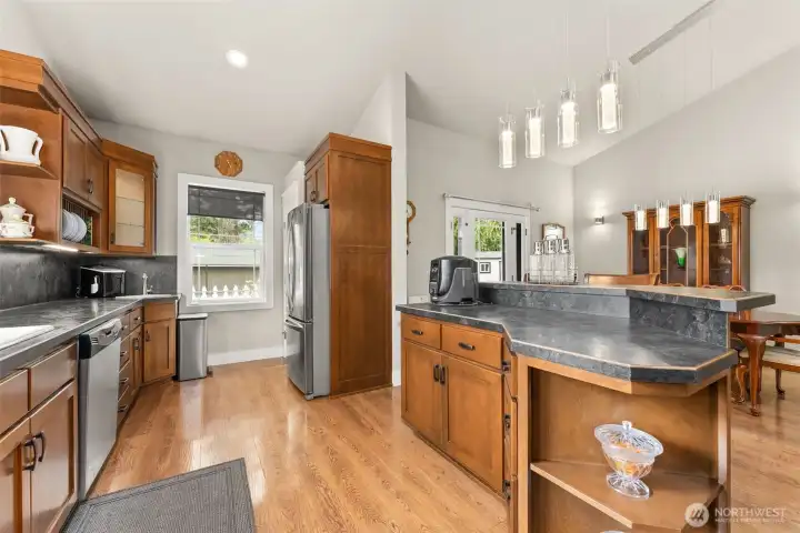 This view shows breakfast bar, pantry (behind fridge) and second sink.