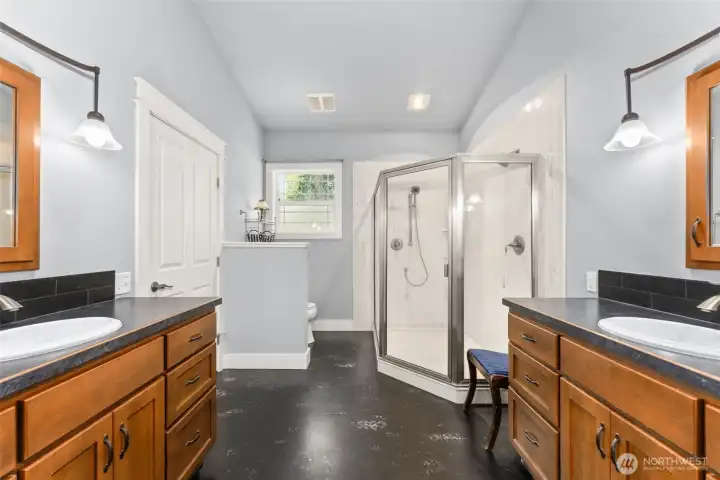 Owner's bath featues double sinks, slab shower
