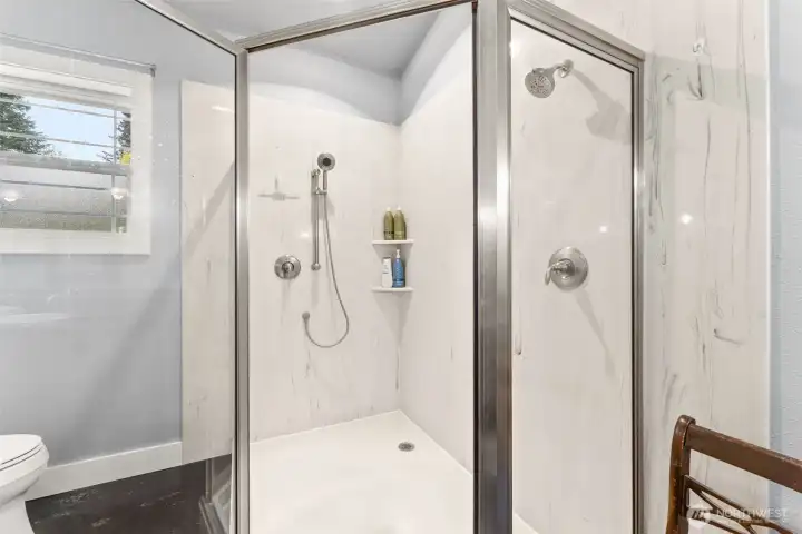 Roomy and gorgeous shower with solid surface porcelain walls.