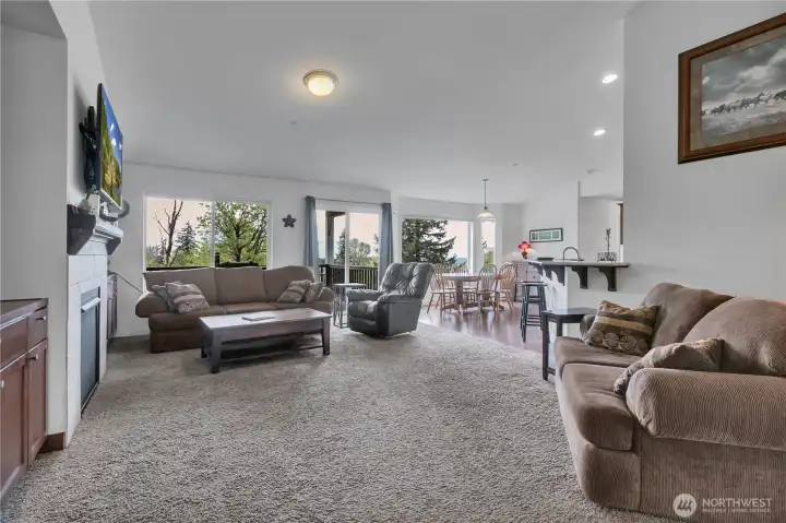 Bright open living and kitchen space featuring an eating bar and easy access to the back patio, perfect for gatherings and barbeques.