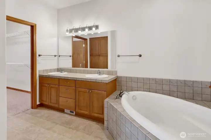 Primary bath with soaker tub and walk-in closet.