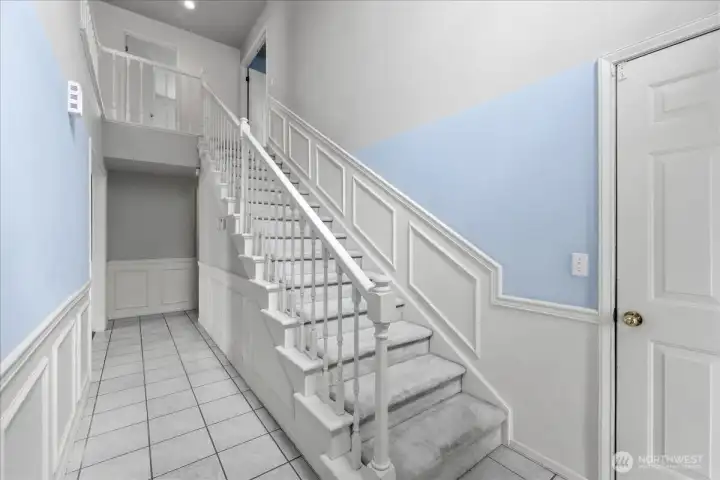Entry stairs to the 3 bedrooms. Door to the right accesses the garage.