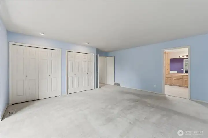 Opposite view of the primary bedroom with double closets.