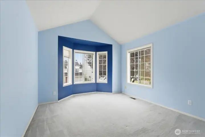 3rd bedroom with bay window and vaulted ceilings.