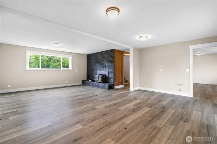 Another view of the ground floor family room and a peek at the beautiful wood panel compliments the entry paneling. This room is plumbed for a bar or kitchenette making this space very flexible.