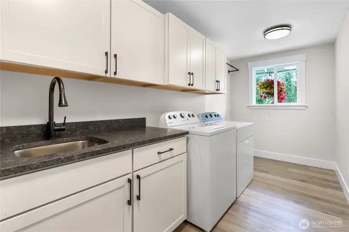 Keeping with the custom remodel of this home, the laundry room also has a rough cut granite counter AND a laundry sink with lots of storage space!