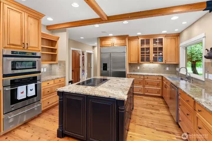 Custom Cabinets, granite slab counters, dual ovens, downdraft cooktop