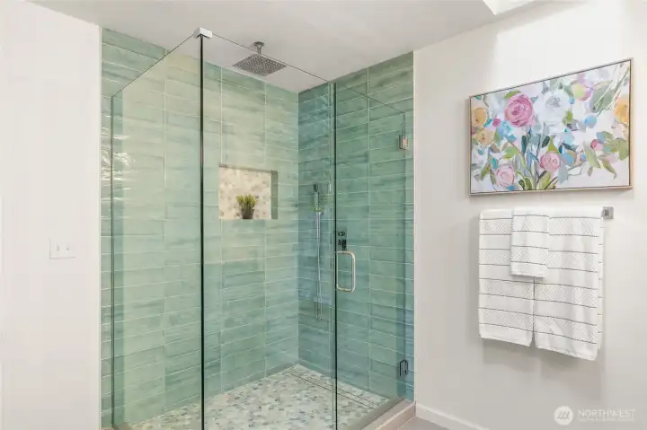Custom tiled primary bath shower with overhead rain shower and hand held shower.