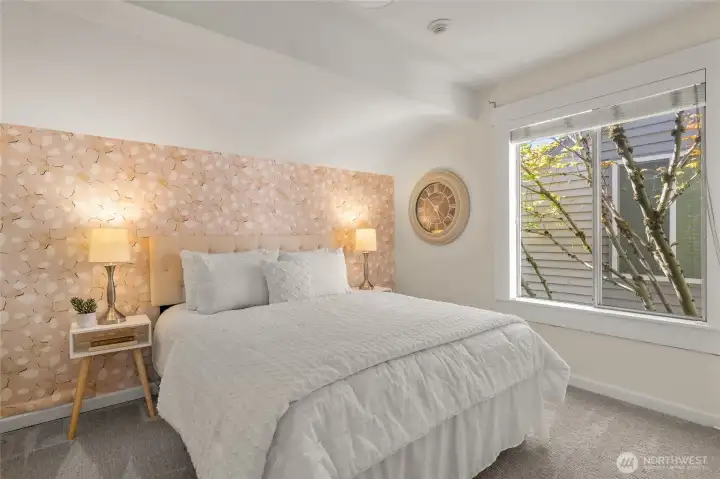 Secondary bedroom on upper level with custom wallpaper.