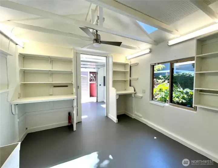 Back of studio space with skylights and built-in drafting desks and shelves. Back of studio space with skylights and built-in drafting desks and shelves.