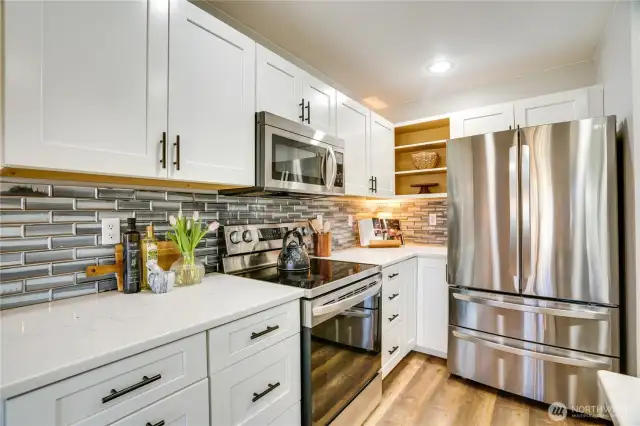 Stainless steel appliance package, new shaker style cabinets, quartz countertops and beautiful tiled backsplash.