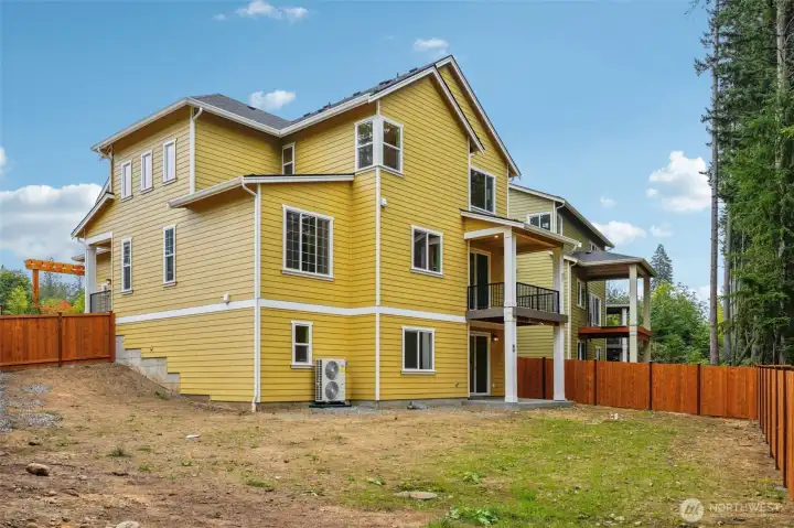Wetlands and large private rearyard. Rear view picture of back of home & yard.  Covered deck & patio on lower level.