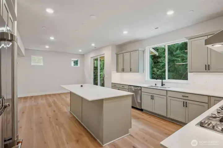 Long Qtz island w/pop-up outlet.  Beautiful Gray painted cabinets/drawers.