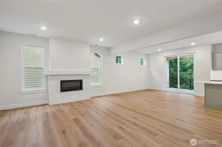 Great room with large windows, gas fireplace with tile and long mantel.