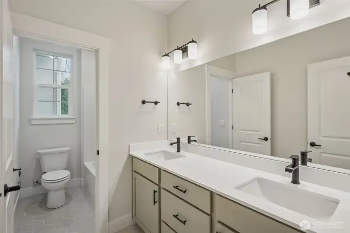 Upper bath room; Large tile flooring, dual sinks, quartz counters, black hardware, plumbing fixtures and lighting. and separate tub/shower and toilet room.