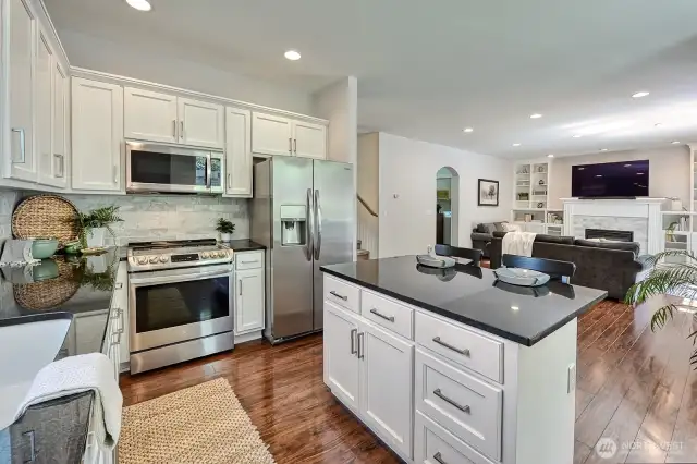Another look at the kitchen with the living room beyond the island.