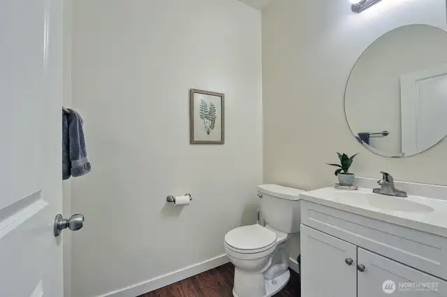 The downstairs powder room is located across the hall from the utility room.