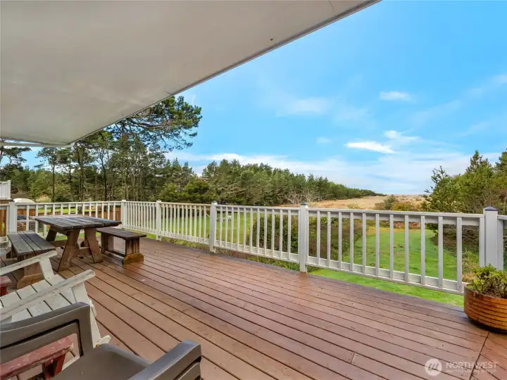 Beautiful views from the large deck overlooking lush landscaping and the Pacific Ocean.
