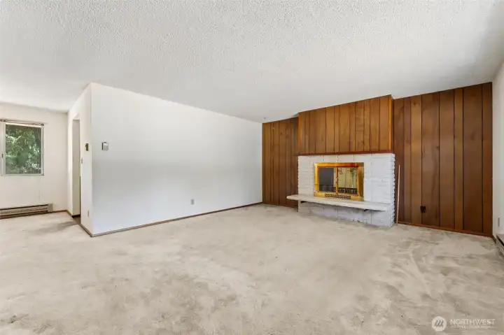 If this living room could talk, it would probably have some incredible stories from the last six decades. Original wood paneling brings warmth and texture to the space, while the raised-hearth fireplace anchors the room with unmistakable mid-century charm. The combination of the stacked stone surround, brass fireplace accents and classic proportions creates a space that feels straight out of an era when homes were designed for gathering around a crackling fire on a rainy Northwest evening. The white walls and ceiling help keep the room feeling bright, while the generous footprint gives future owners endless possibilities. Lean into the vintage aesthetic, update selectively or start fresh and create something entirely new. If this living room could talk, it would probably have some incredible stories from the last six decades. Original wood paneling brings warmth and texture to the space, while the raised-hearth fireplace anchors the room with unmistakable mid-century charm. The combination of the stacked stone surround, brass fireplace accents and classic proportions creates a space that feels straight out of an era when homes were designed for gathering around a crackling fire on a rainy Northwest evening. The white walls and ceiling help keep the room feeling bright, while the generous footprint gives future owners endless possibilities. Lean into the vintage aesthetic, update selectively or start fresh and create something entirely new.