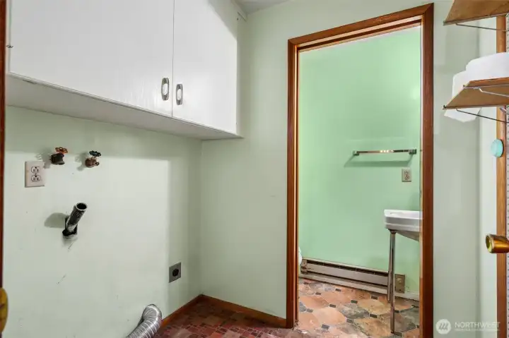 Function meets practicality in this dedicated laundry room, conveniently located just steps from the kitchen and adjacent half bath. There's room for a full-size high-efficiency washer and dryer setup, while the upper cabinetry provides valuable storage for cleaning supplies, household essentials and all those things that never seem to have a proper home. The durable vinyl flooring continues through the space, creating easy maintenance and a cohesive connection to the nearby kitchen. Through the doorway you'll find the home's half bath, adding extra convenience to the floorplan. Behind the scenes, the home is connected to public water service and is equipped with an electric water heater located in the garage. Function meets practicality in this dedicated laundry room, conveniently located just steps from the kitchen and adjacent half bath. There's room for a full-size high-efficiency washer and dryer setup, while the upper cabinetry provides valuable storage for cleaning supplies, household essentials and all those things that never seem to have a proper home. The durable vinyl flooring continues through the space, creating easy maintenance and a cohesive connection to the nearby kitchen. Through the doorway you'll find the home's half bath, adding extra convenience to the floorplan. Behind the scenes, the home is connected to public water service and is equipped with an electric water heater located in the garage.