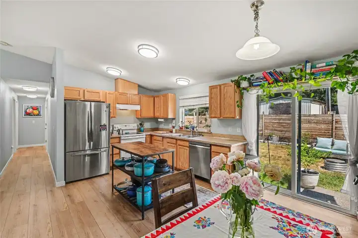 The bright kitchen features warm natural-toned cabinetry and a large window above the sink, creating an inviting space for everyday living.