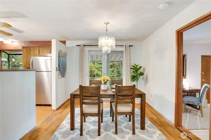 French doors lead from the dining area to a covered patio. The door on the right opens to a bonus room with its own backyard door, access to the garage, and a 1/2 bath. French doors lead from the dining area to a covered patio. The door on the right opens to a bonus room with its own backyard door, access to the garage, and a 1/2 bath.