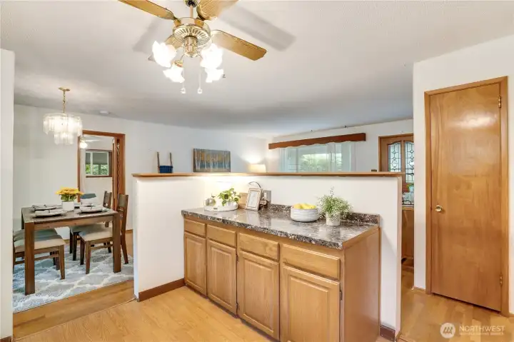A buffet counter offers extra work space for cooking and additional cabinets below. Notice the pantry closet beyond for convenient storage. A buffet counter offers extra work space for cooking and additional cabinets below. Notice the pantry closet beyond for convenient storage.