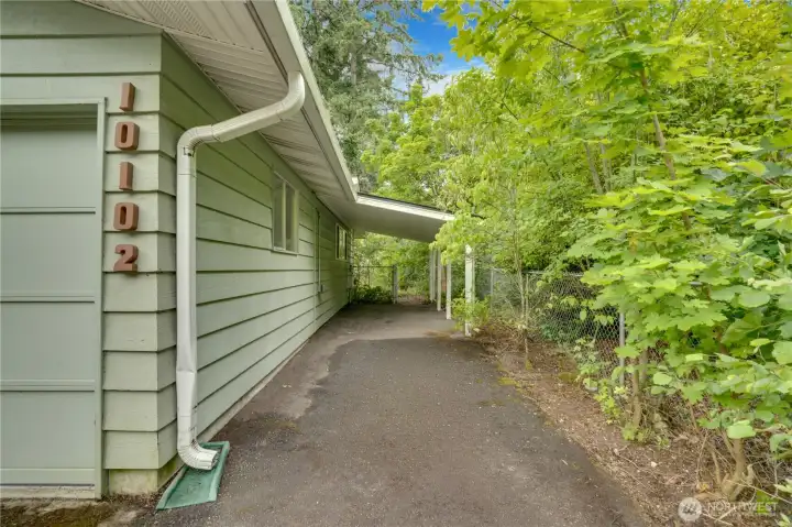 The paved driveway extends to this carport for smaller vehicles or covered storage. Notice the gate to the back yard. The paved driveway extends to this carport for smaller vehicles or covered storage. Notice the gate to the back yard.