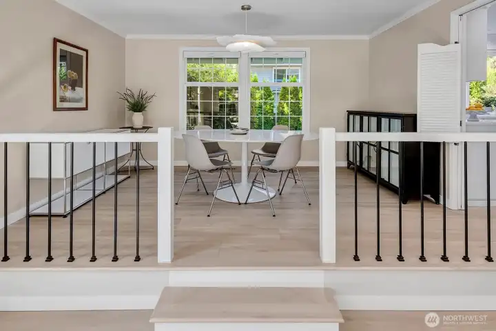 The dining room features large windows that offer a picturesque view of the private back yard, inviting natural light into the space and creating a serene atmosphere for meals and gatherings.