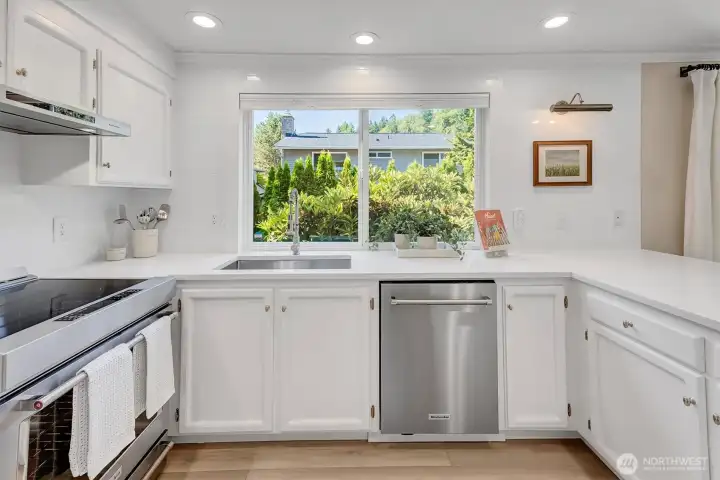 Modern undermount stainless steel sink area featuring a beautiful view of the private backyard.